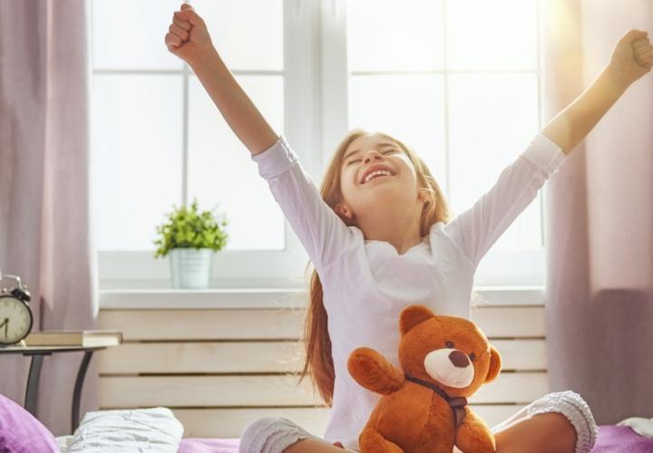 Young girl wakes up and stretches