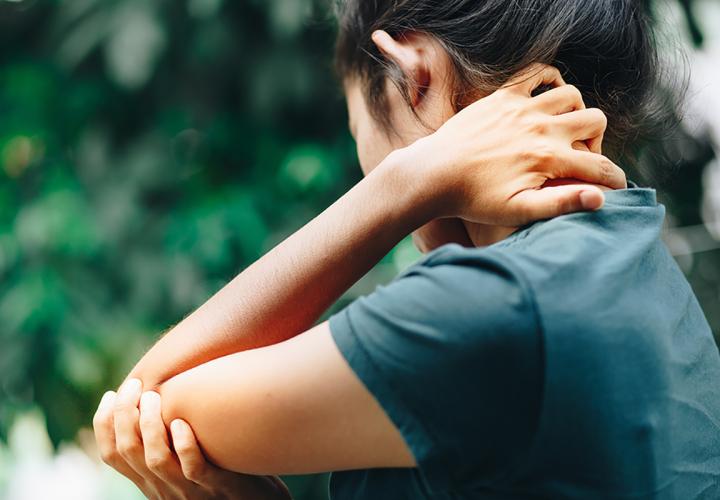 woman holding her elbow in pain