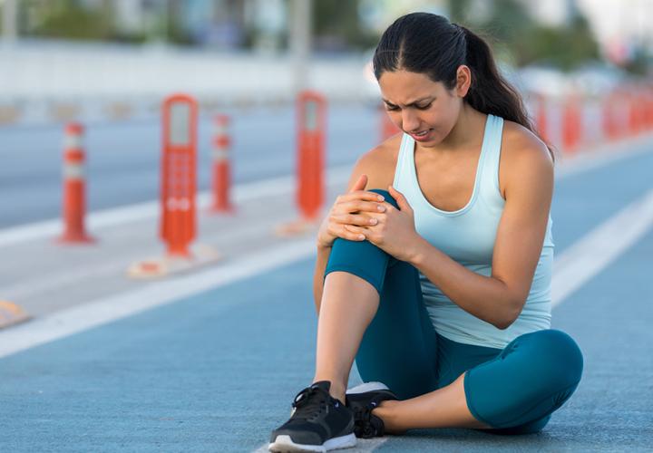 woman holding her knee in pain