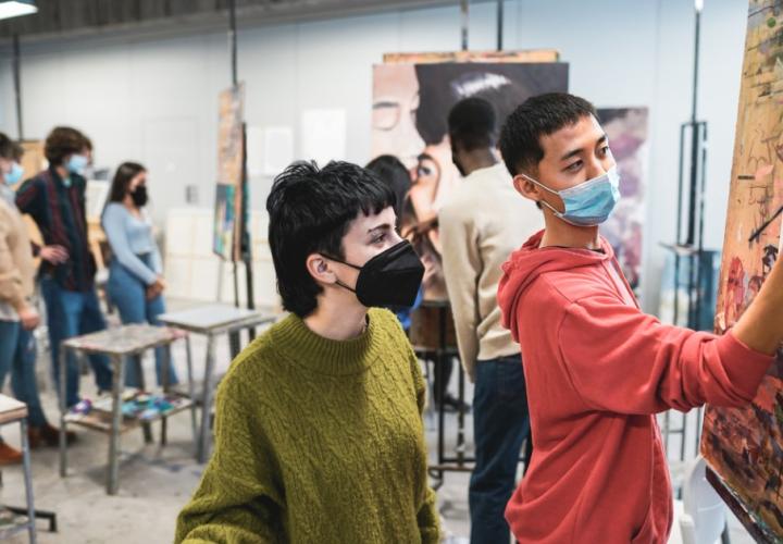 Two high schoolers work on a painting