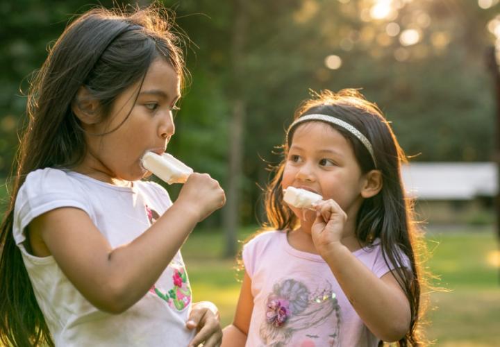 Sisters eating popsicles