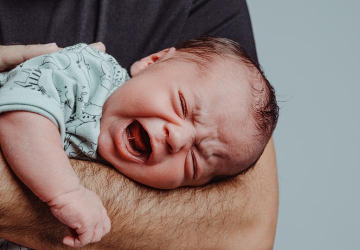 Newborn screams inconsolably in dad's arms