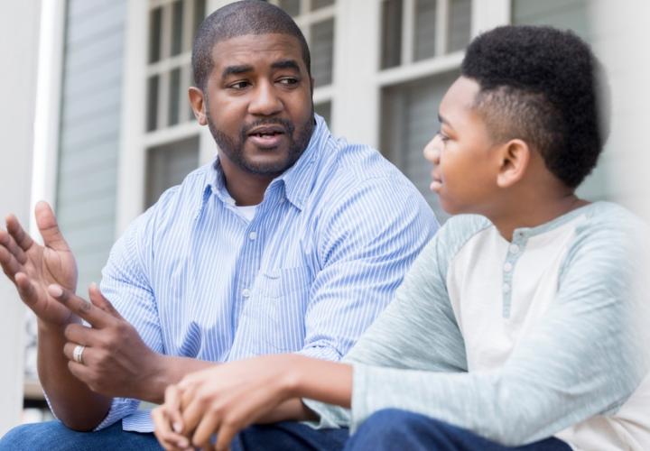 Attentive school-aged boy, listening to father during conversation