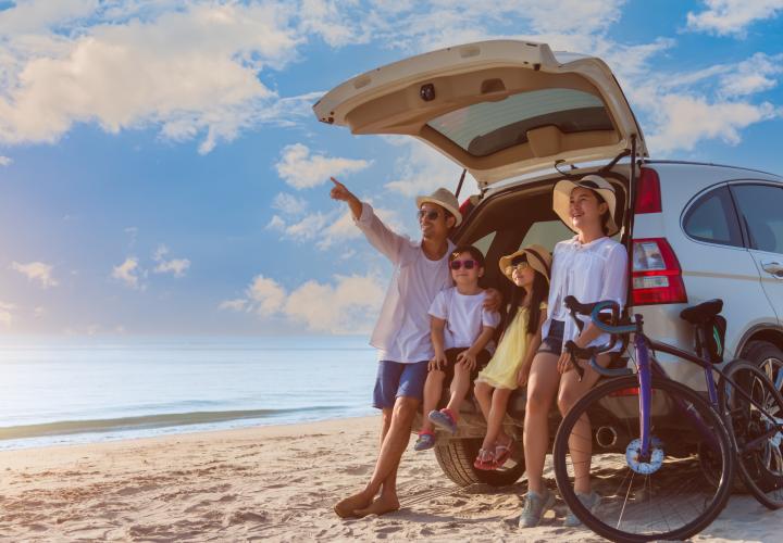Family outside camper in summer, on beach