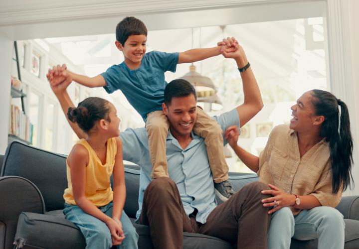 A mother in father playing with their children in their home. 