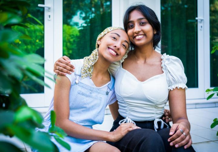 Two young adult female friends hugging