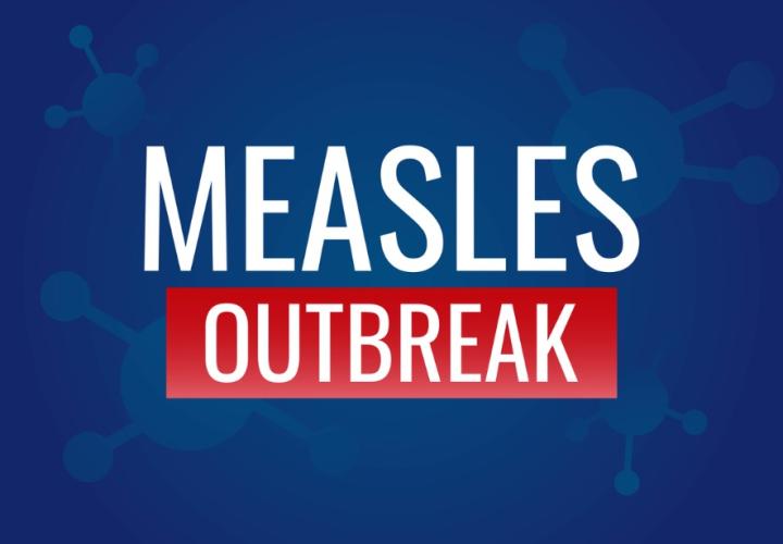 White and red text Measles Outbreak against blue background