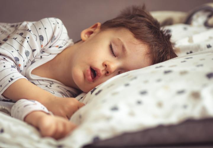 Young boy asleep in bed with mouth open, maybe mouth breathing