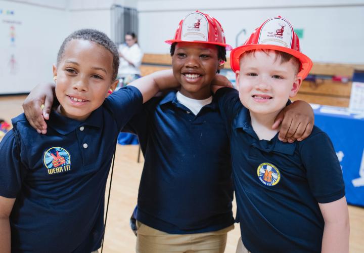 3 boys standing side by side with arms around each other