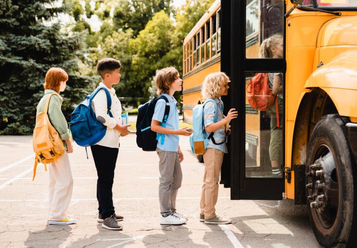 Kids getting on a school bus