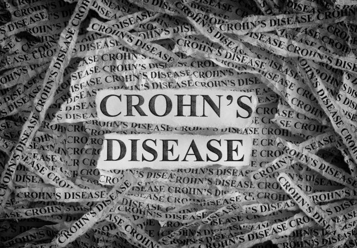 Torn pieces of paper with the words "Crohn's Disease"