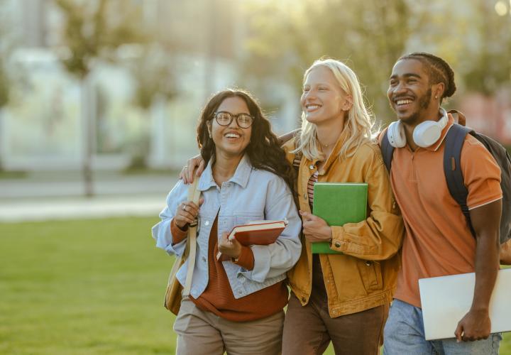 Three students walking on a college campus. 