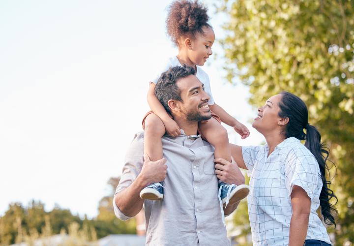 A mom, dad and daughter outside together.