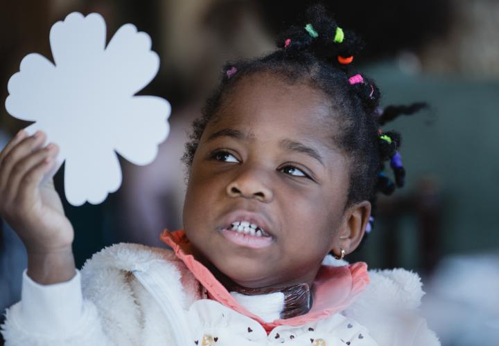 Adorable girl toddler holding a shamrock cutout. Was once extremely premature, now thriving 