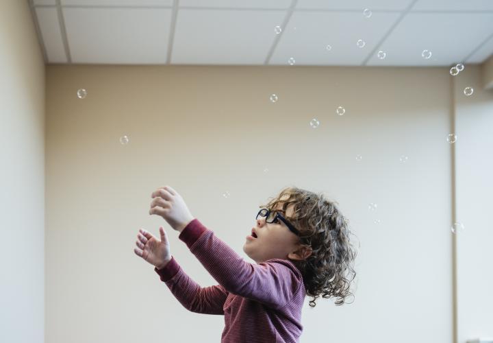 A patient plays with bubbles during a developmental pediatrics evaluation.