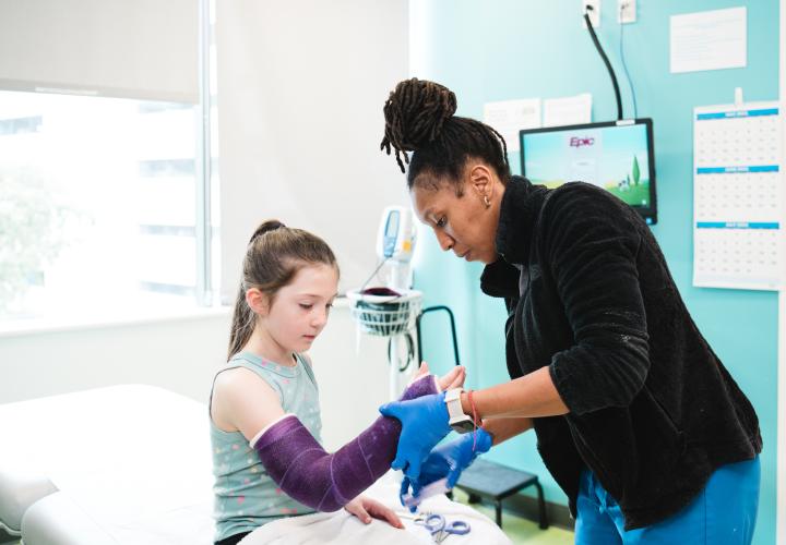 An orthopedic technologist wraps a cast on a patient.