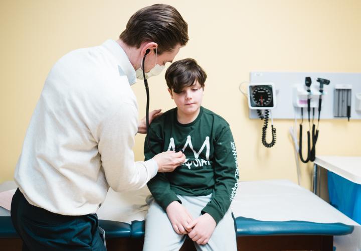 Cardio-oncology clinic doctor listening to patient's heart with stethescope