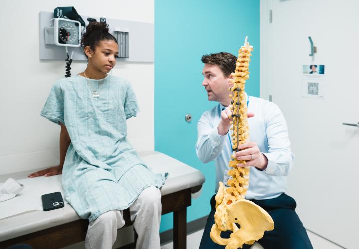 Dr. Stelzer talks with a patient in a spine clinic. Dr. Stelzer talks with a patient in a spine clinic.