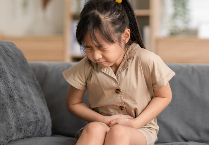 Little girl with UTI, holding bladder in pain