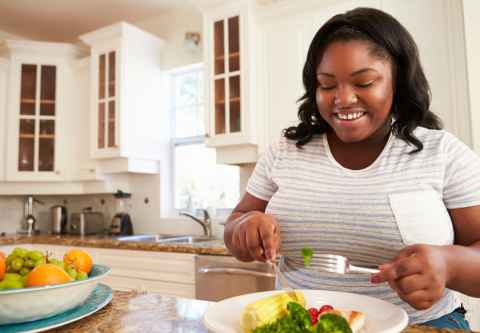 overweight female eating healthy on her own