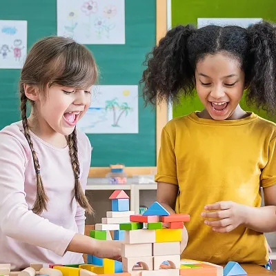 Kids in a classroom playing with wooden blocks