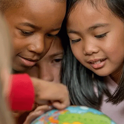 Groups of kids looking at a globe