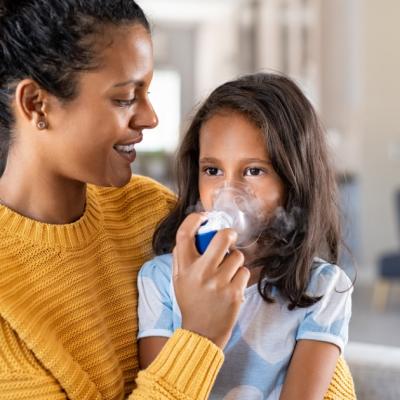 Mother helping her daughter use a nebulizer