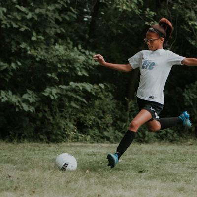 A young girl plays soccer
