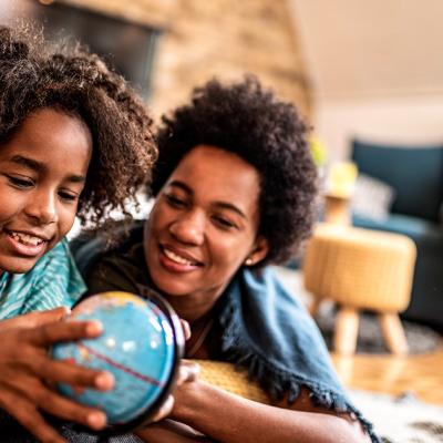 A mother and daughter look at a globe
