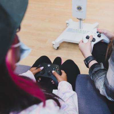 Two young women hold video game controllers