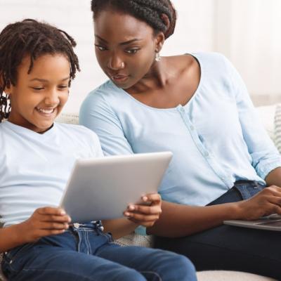 A mother and child look at an ipad