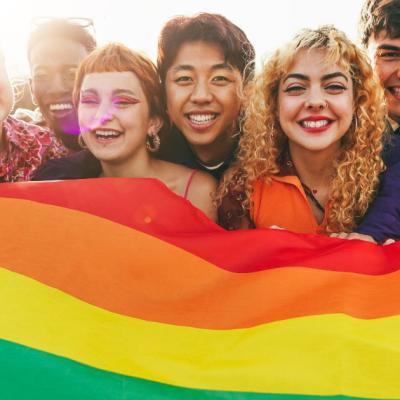 A group of friends hold a pride flag