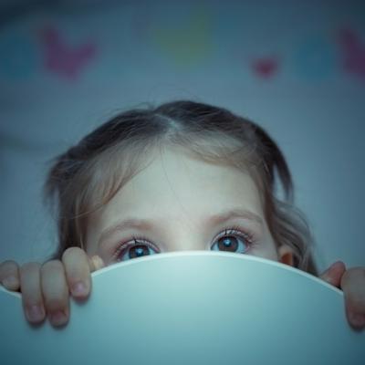 Young girl frightened in bed at night