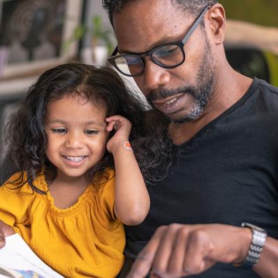 A father and his daughter reading a book