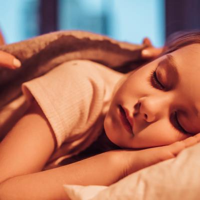 Young girl being tucked into bed