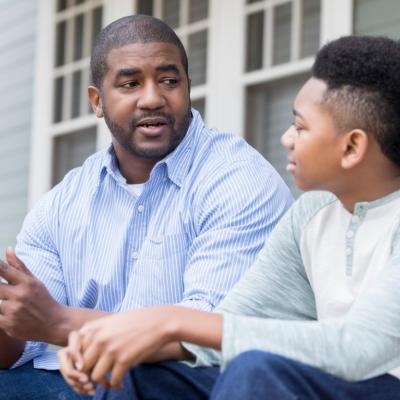 Attentive school-aged boy, listening to father during conversation