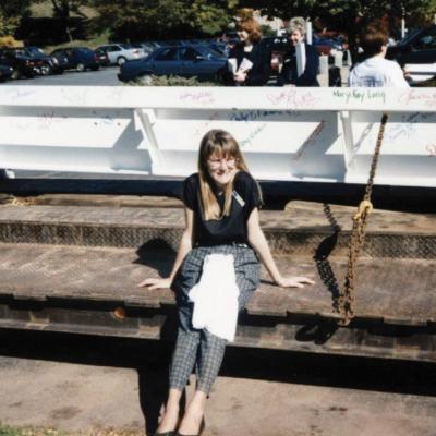 Woman sitting on concrete in front of steel beam for Newington Children's Hospital, circa 1996