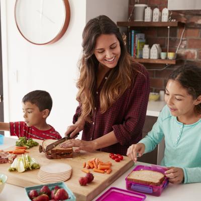 Mom with two school-aged kids in kitchen food prepping