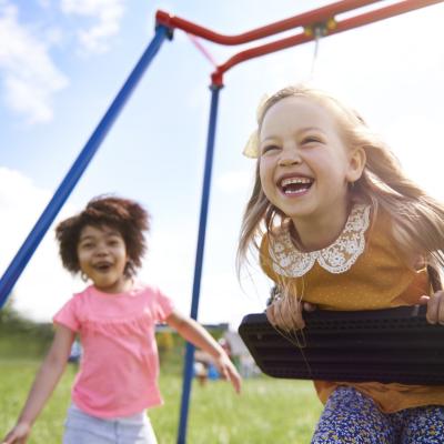 Two young girls playing joyfully on playground