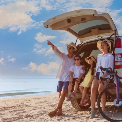 Family outside camper in summer, on beach