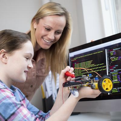 Teacher with middle school aged girl, building robot, mental health tips for caregivers and school staff