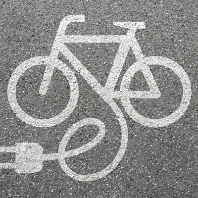 Chalk illustration of an electronic bike on pavement. E-bike injuries are rising fast