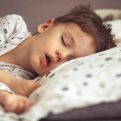 Young boy asleep in bed with mouth open, maybe mouth breathing
