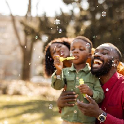 Family pblowing bubbles outside