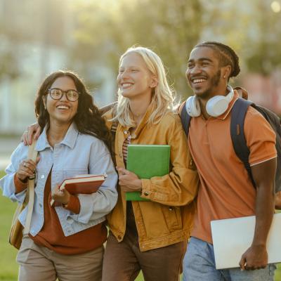 Three students walking on a college campus. 