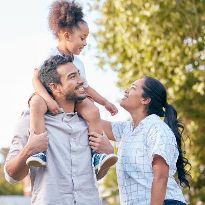 A mom, dad and daughter outside together.