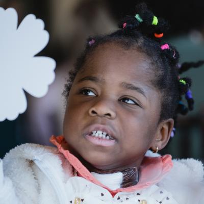 Adorable girl toddler holding a shamrock cutout. Was once extremely premature, now thriving 