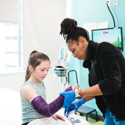 An orthopedic technologist wraps a cast on a patient.