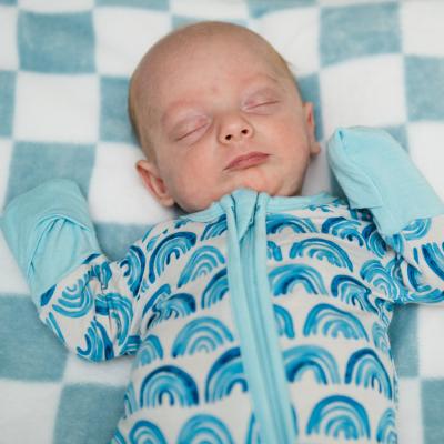 A newborn asleep on a blanket.