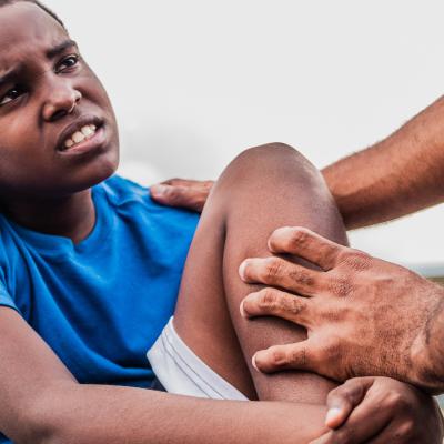 Child athlete with injured knee on field
